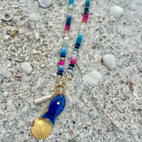 Tempest Necklace unique beaded design displayed on sandy beach surface with natural shells - one of a kind coastal inspired jewelry