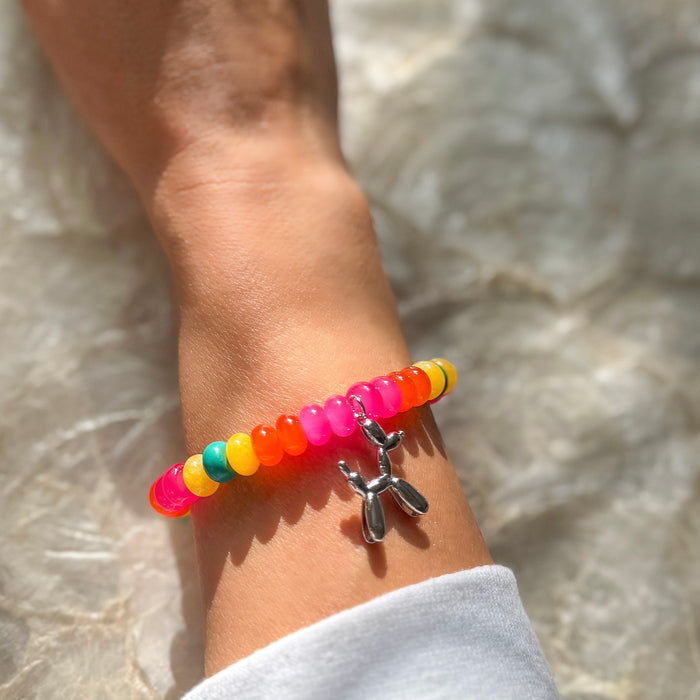 Carnival Candy colorful beaded stretch bracelet worn on wrist with rainbow translucent beads and silver balloon animal charm