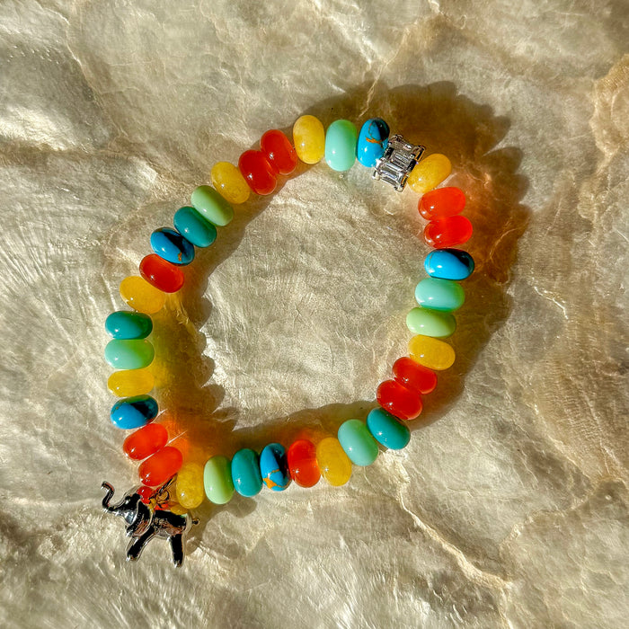 Happy Elephant colorful stretch bracelet with rainbow glossy beads red orange yellow green blue and silver elephant charm on marble surface