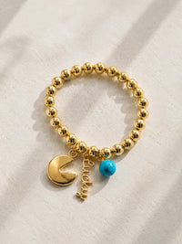 Gold tone hematite stretch bracelet with fortune cookie charm, Lucky script charm, and blue howlite stone bead — one of a kind handmade bracelet by Shop Lucky Charms